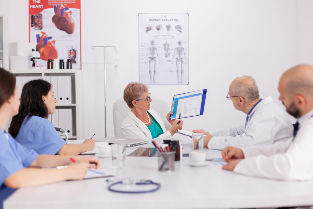 senior pediatrician woman discussing sickness treatment using clipboard for medical presentation
